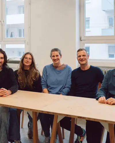 5 Personen am Tisch, am Tag der Unterzeichnung des Auftrags